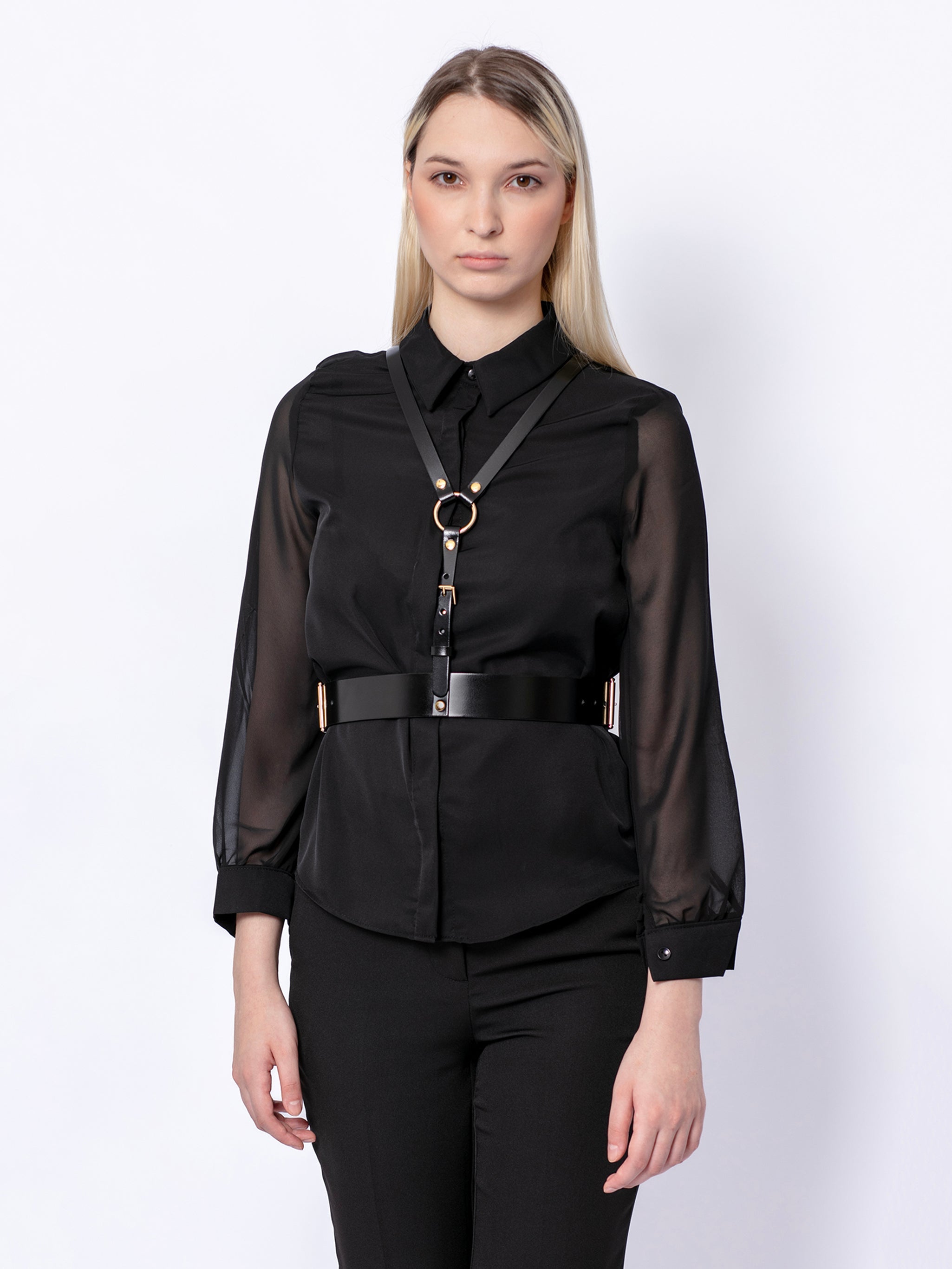 Front view of black leather harness worn by model over black shirt.
