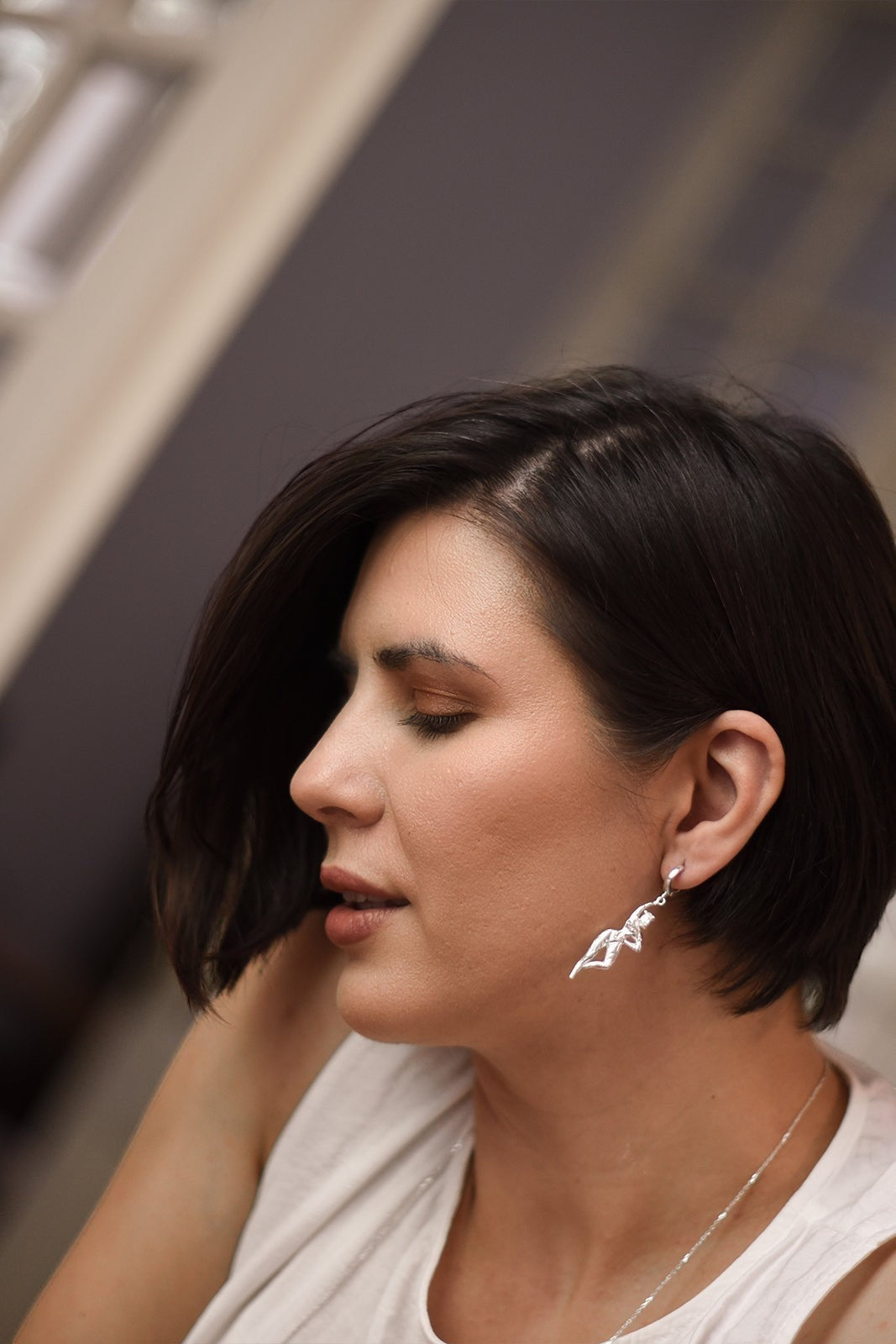 Ce Fain! Aethera sterling silver goddess huggie earrings worn by a woman with short dark hair