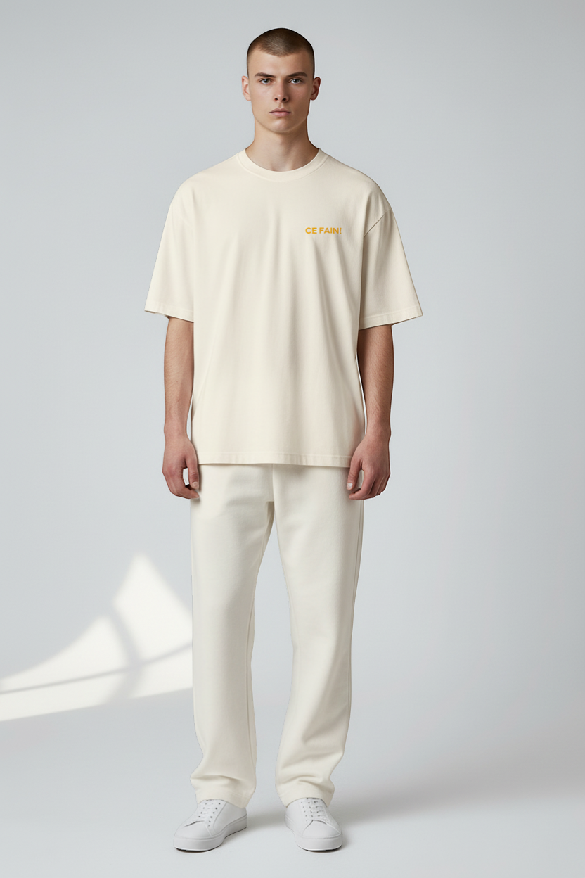 Ce Fain! cream 100% organic cotton t-shirt with subtle chest text and a bold back illustration. Regular fit, medium-weight knit.