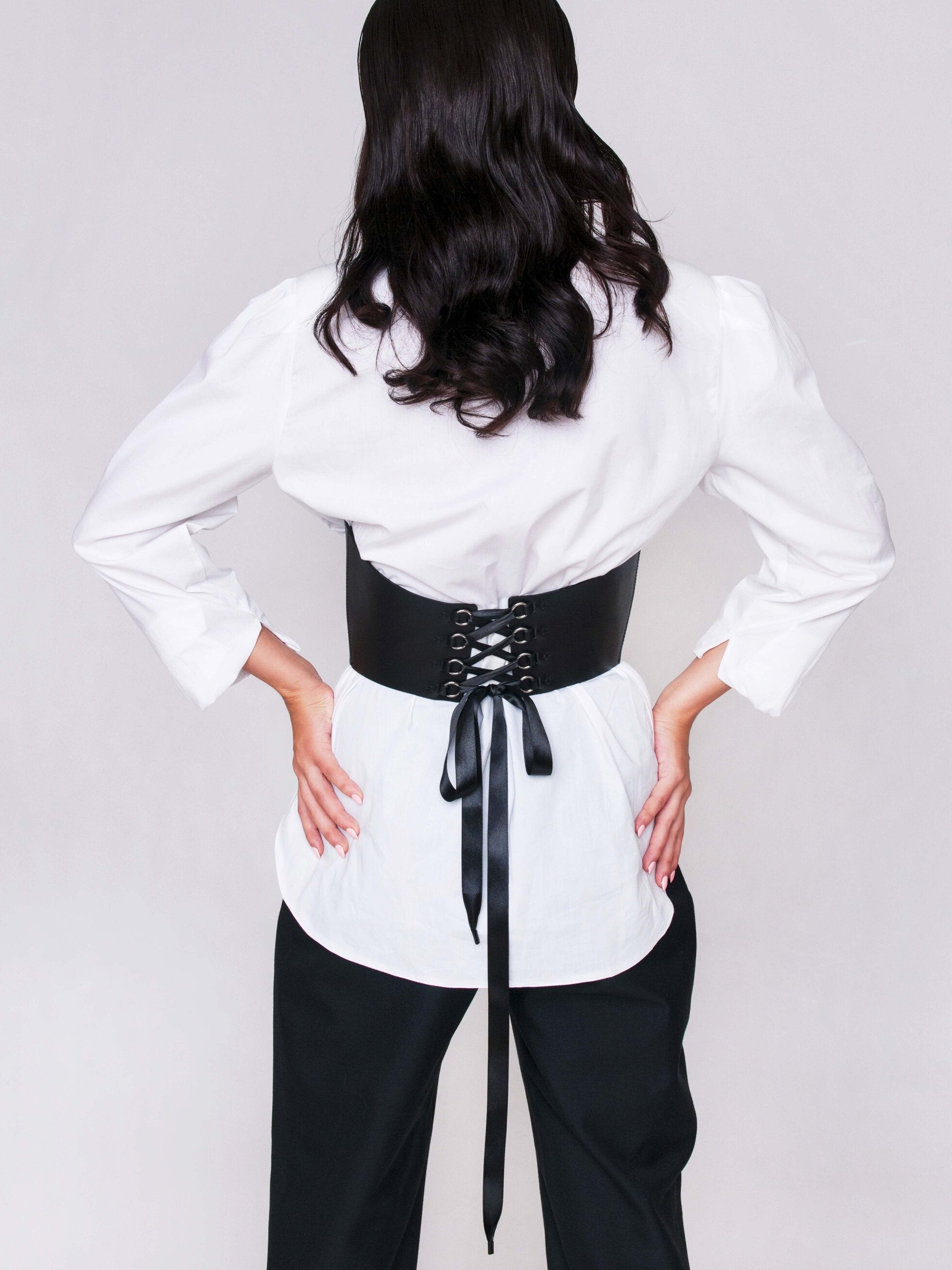 Back view of underbust corset lacing worn by woman.