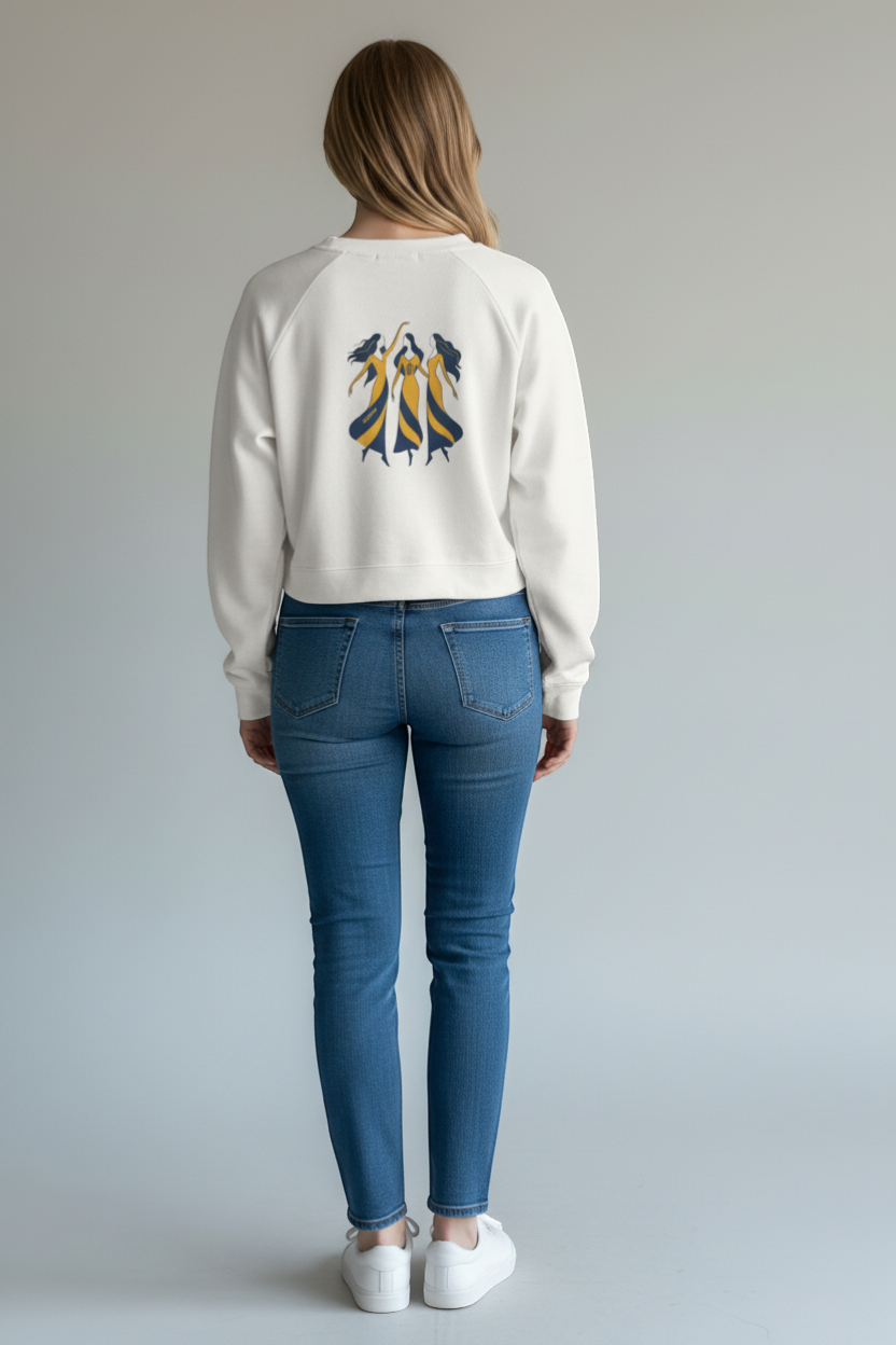 Ce Fain! white cropped fleece pullover with raglan sleeves and a vintage graphic of three women in yellow and blue dresses.